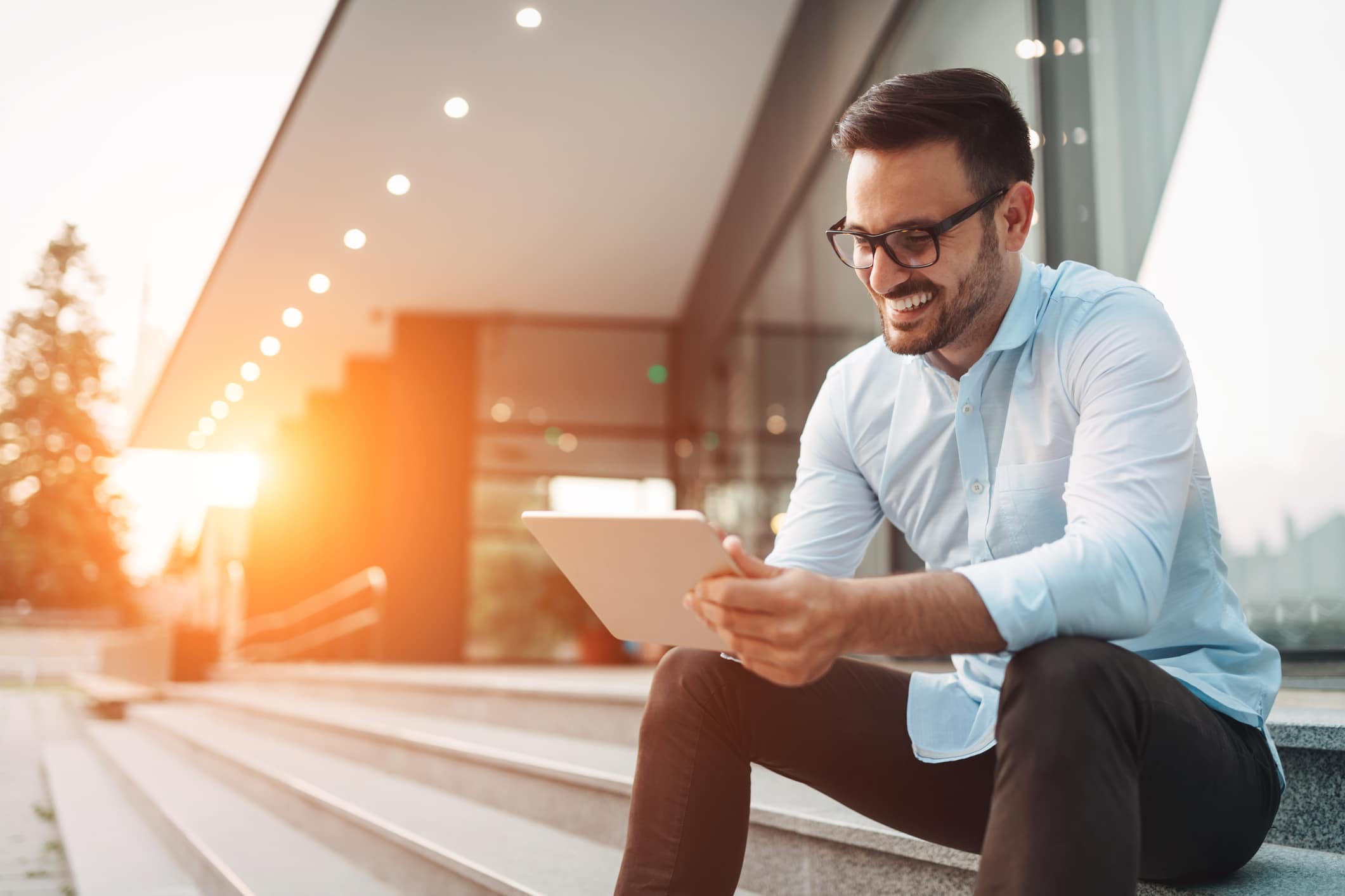 Portrait of businessman in glasses holding tablet